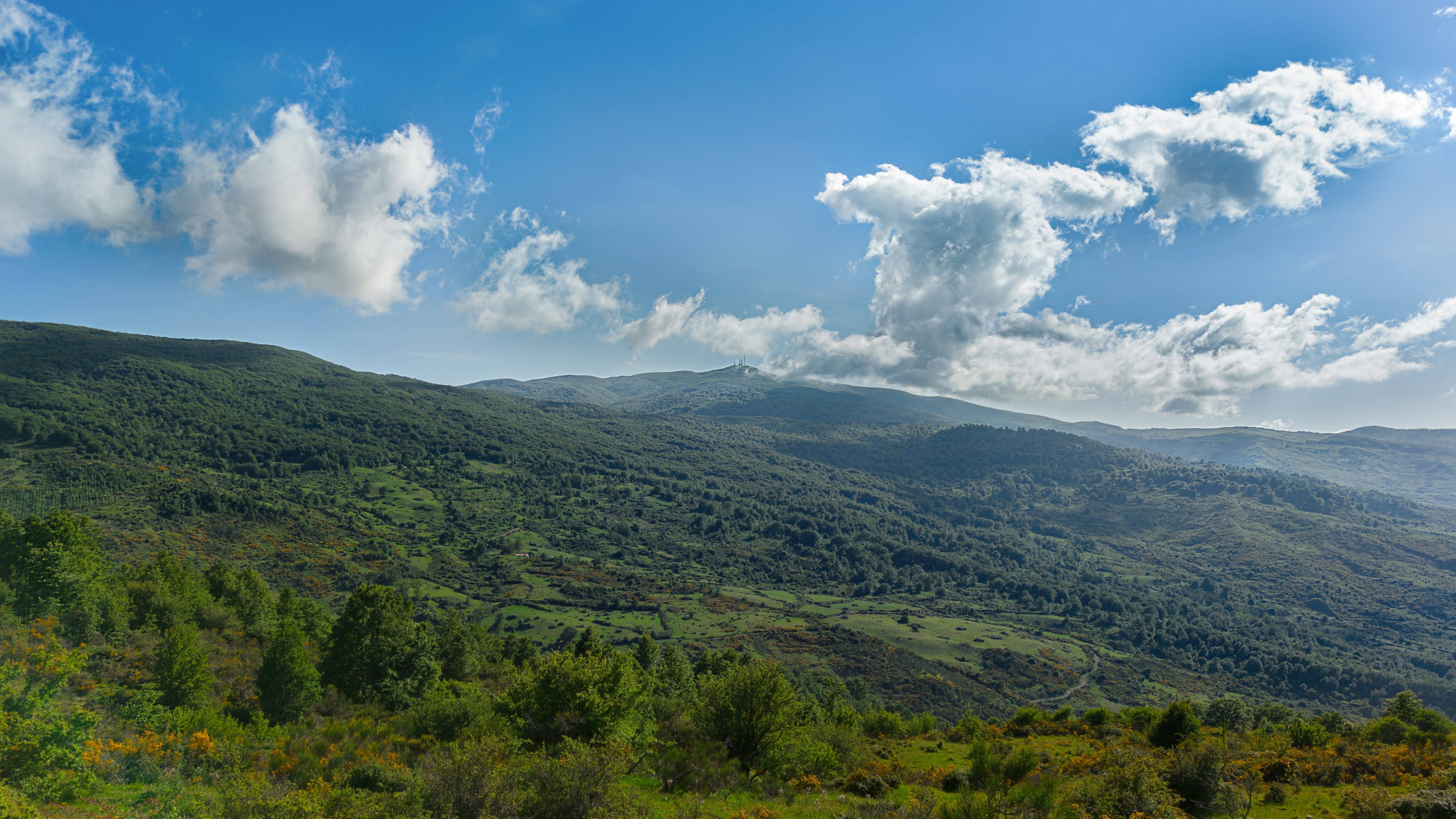 green mountains under white clouds and blue sky during daytime